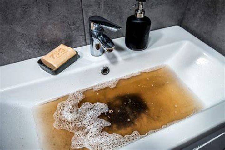 A bathroom sink filled with dirty water in Phasmophobia.