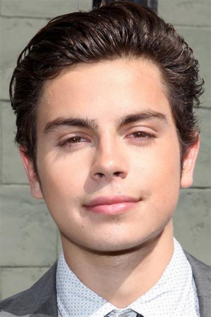 Jake T. Austin smiling in front of a black background