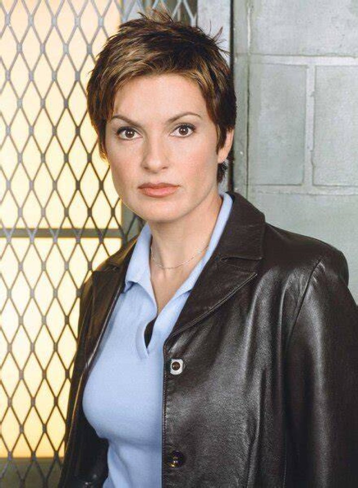 Olivia Benson standing in front of a cork board with Stabler seated behind a desk
